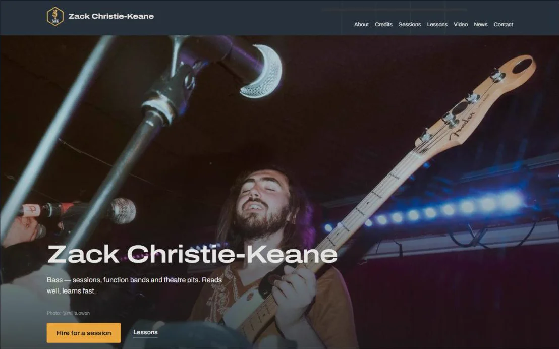 Zack Christie-Keane website homepage: a live photo of Zack playing bass under stage lights, with buttons to hire him for a session or book lessons